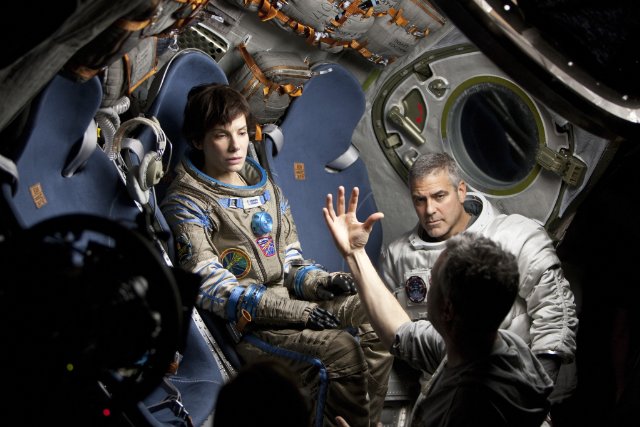 Sandra Bullock and George Clooney speak with director Alfonso Cuaron while making "Gravity."